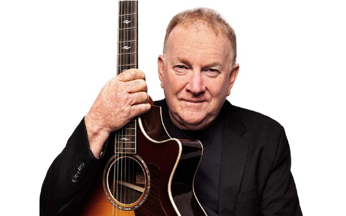 Graeme Connors holding his guitar