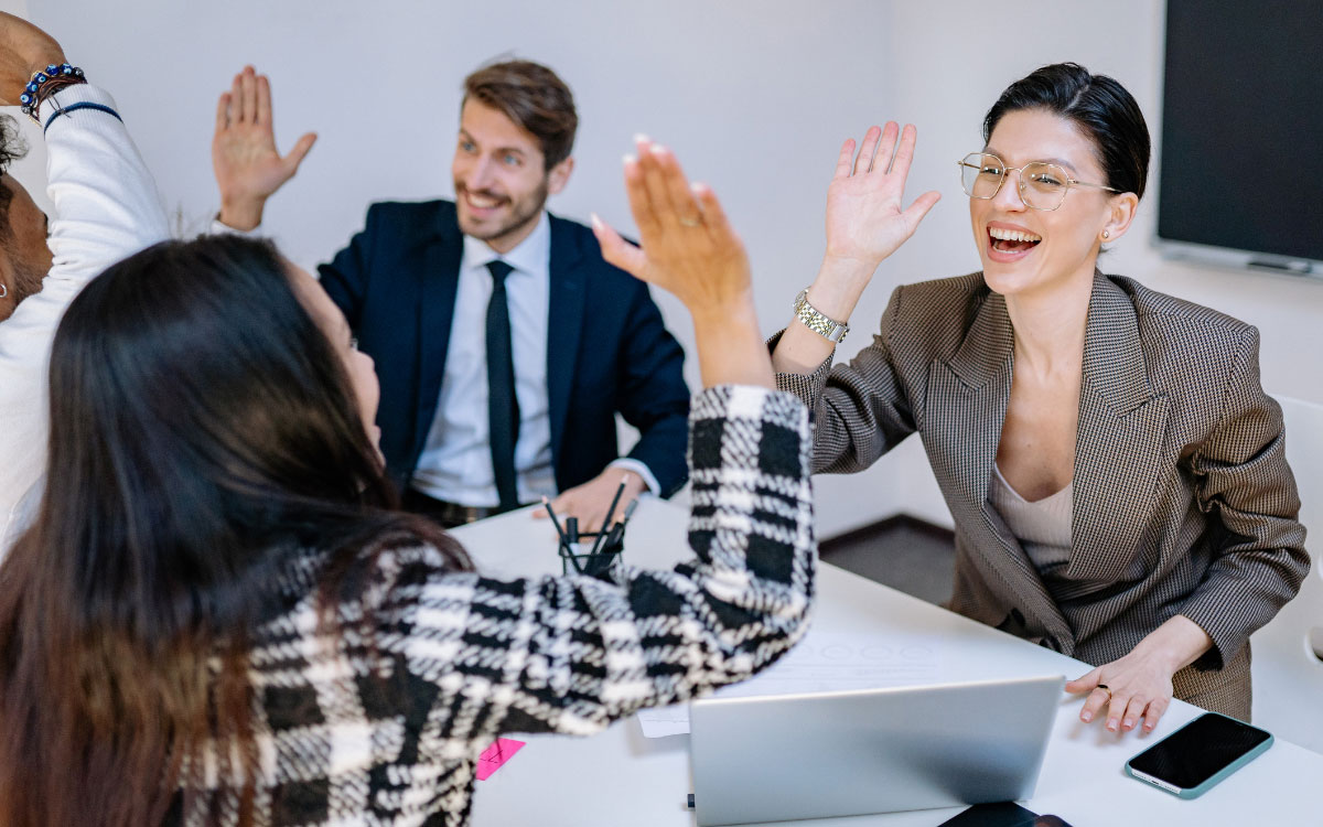 Office workers high fiving each other