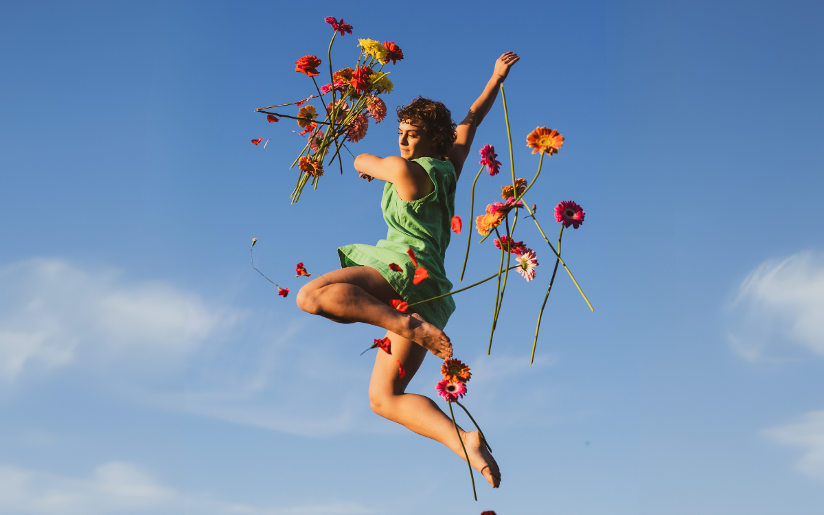 Person jumping in the air with flowers