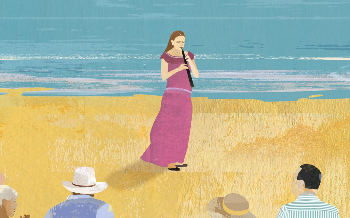 A woman playing a clarinet on the beach