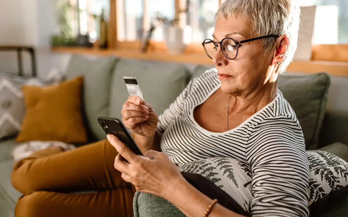 Senior woman online shopping at home with credit card