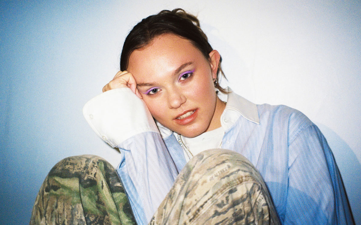 Female performer with purple eyeshadow and cargo pants