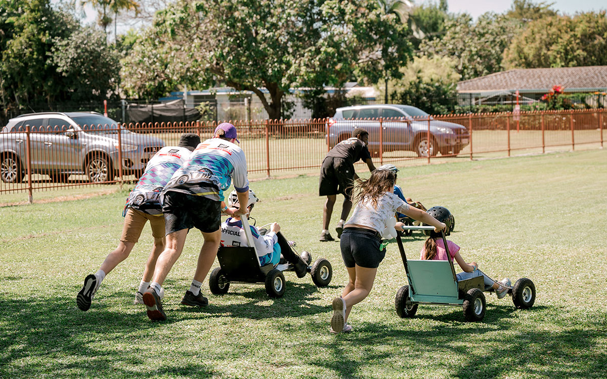 Adults pushing two girls in go carts
