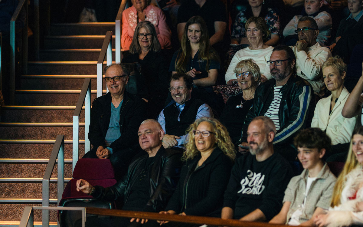 Crowd sitting in a theatre smiling