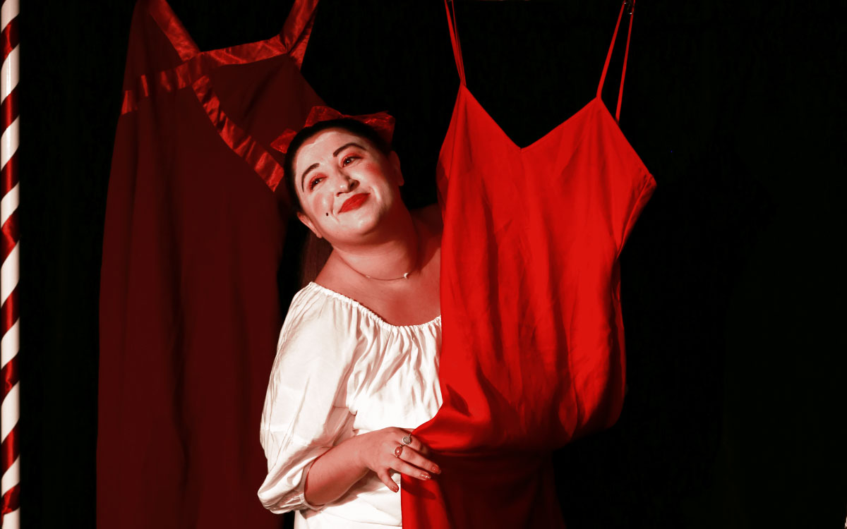 Woman smiling while holding a red dress