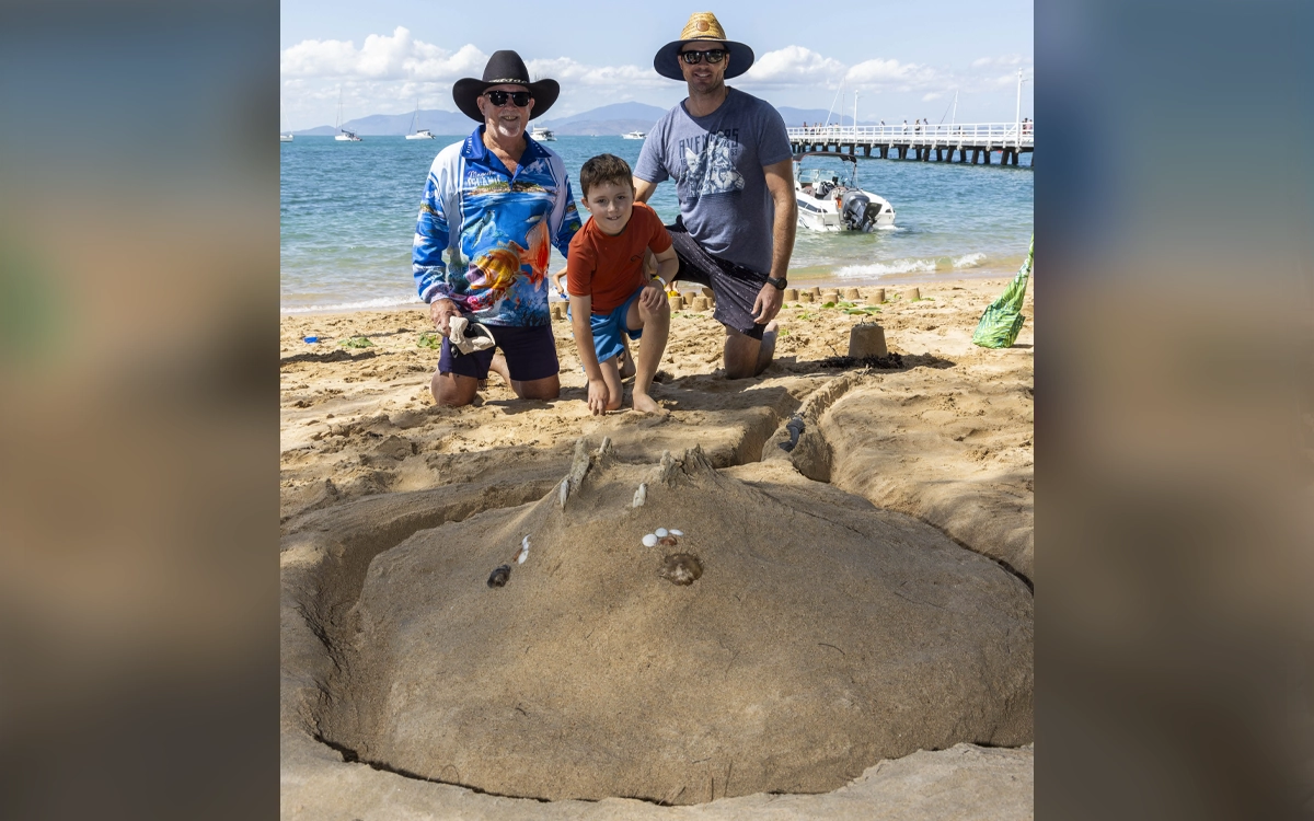 A family building a sting ray sand sculpture