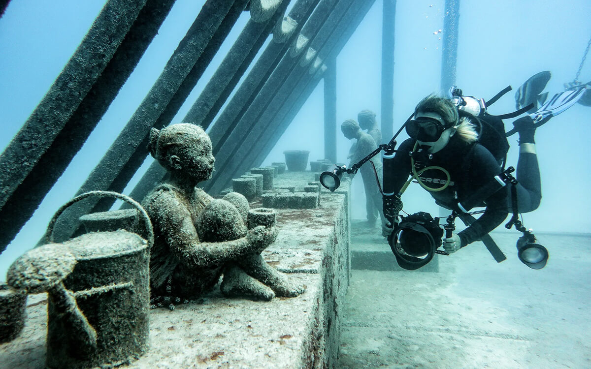Woman snorkelling near underwater art piece