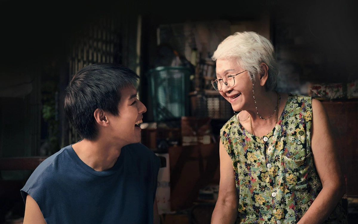 A scene from the movie with 'M' smiling while talking to his grandmother.