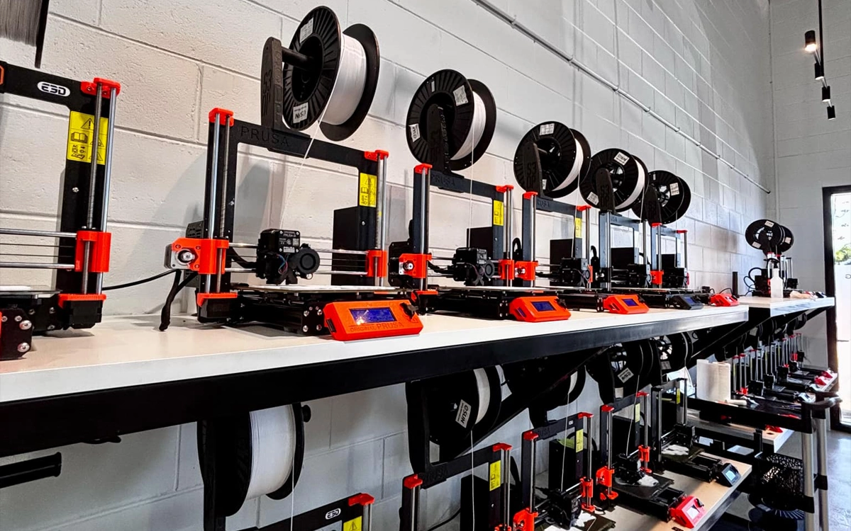 Two shelves of 3D printers