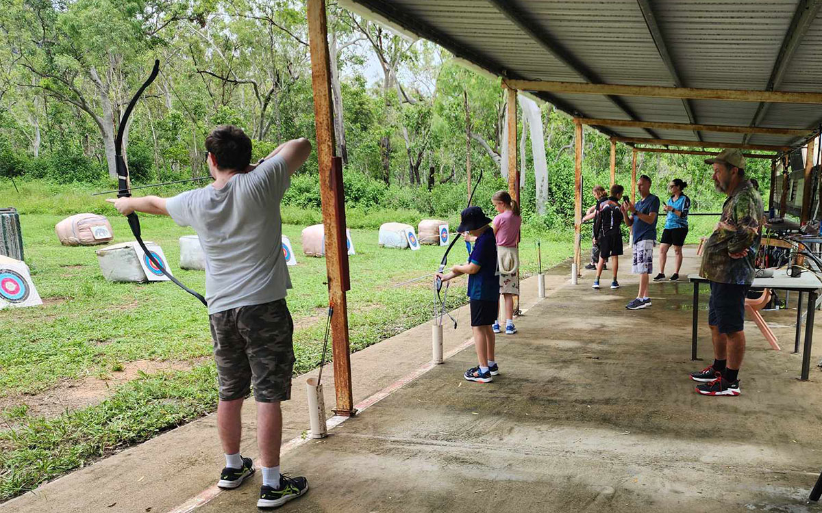 Kids doing archery under adult supervision