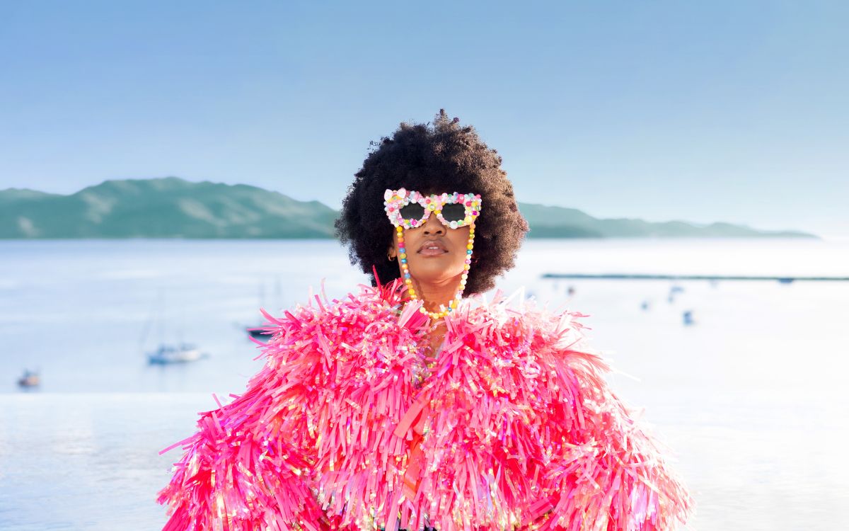 Person dressed in pink feathers and colourful sunnies