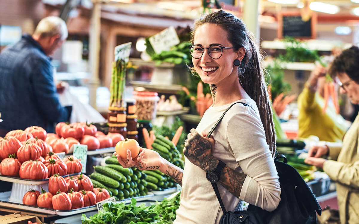 A smiling woman buying vegetables