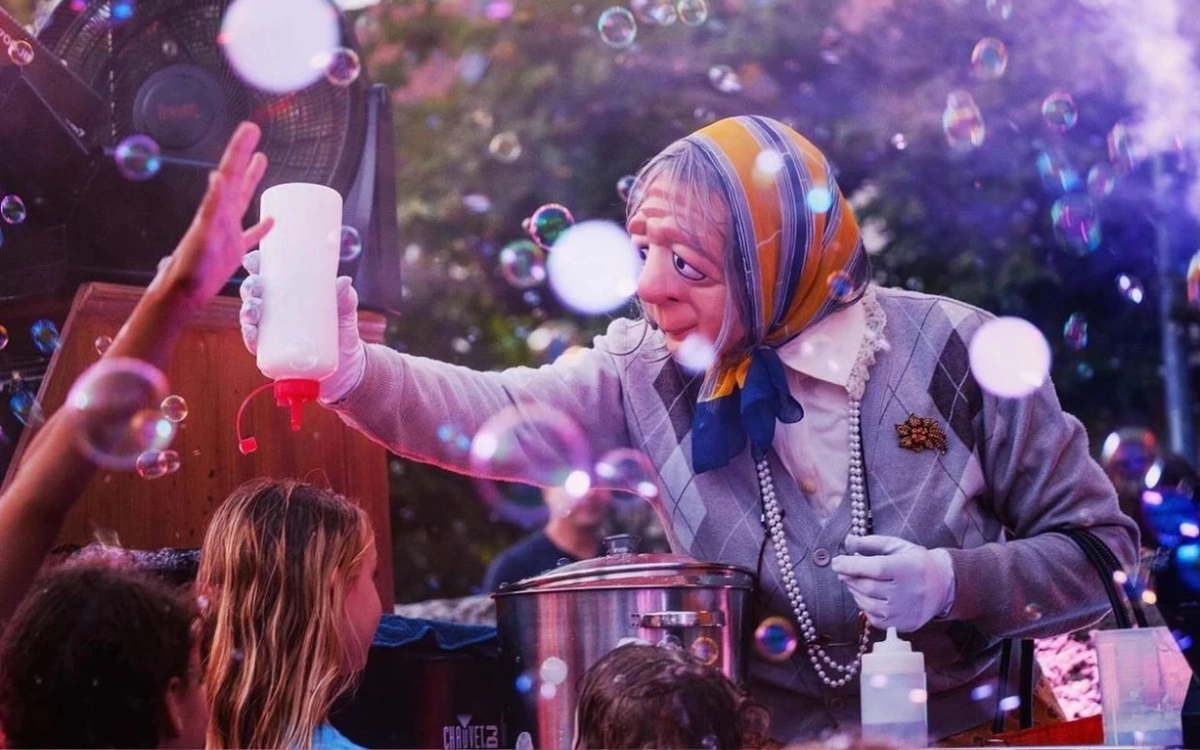 A woman handing out drinks amongst bubbles