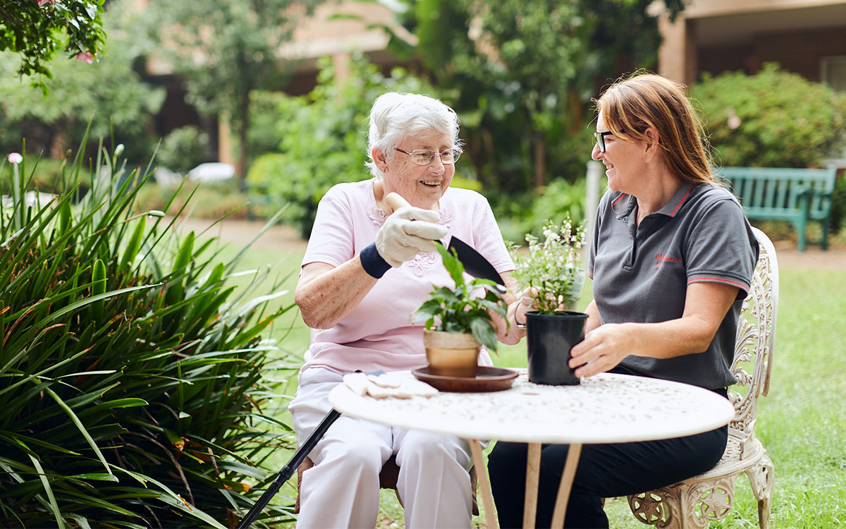 Elderly lady gardening with Just Better Care staff member